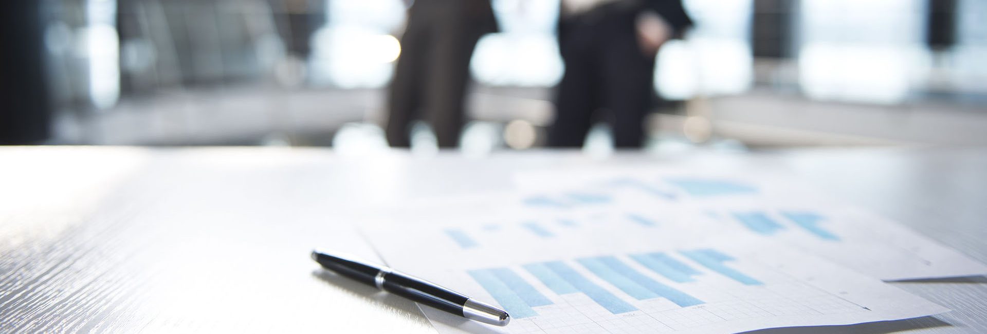 37166897 - focus on documents and pen on the table. blurred people on background.